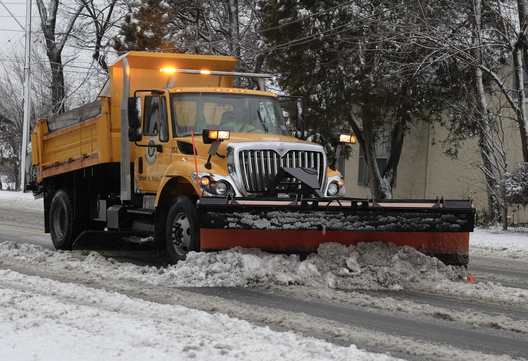 Snow plow removing snow from a street.