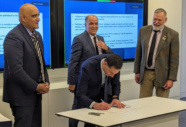 Photo of APWA President Gary Losier, CEO Scott Grayson, and Federal Highway Administrator (FHWA) Shailen Bhatt signing an updated memorandum of agreement (MOA)