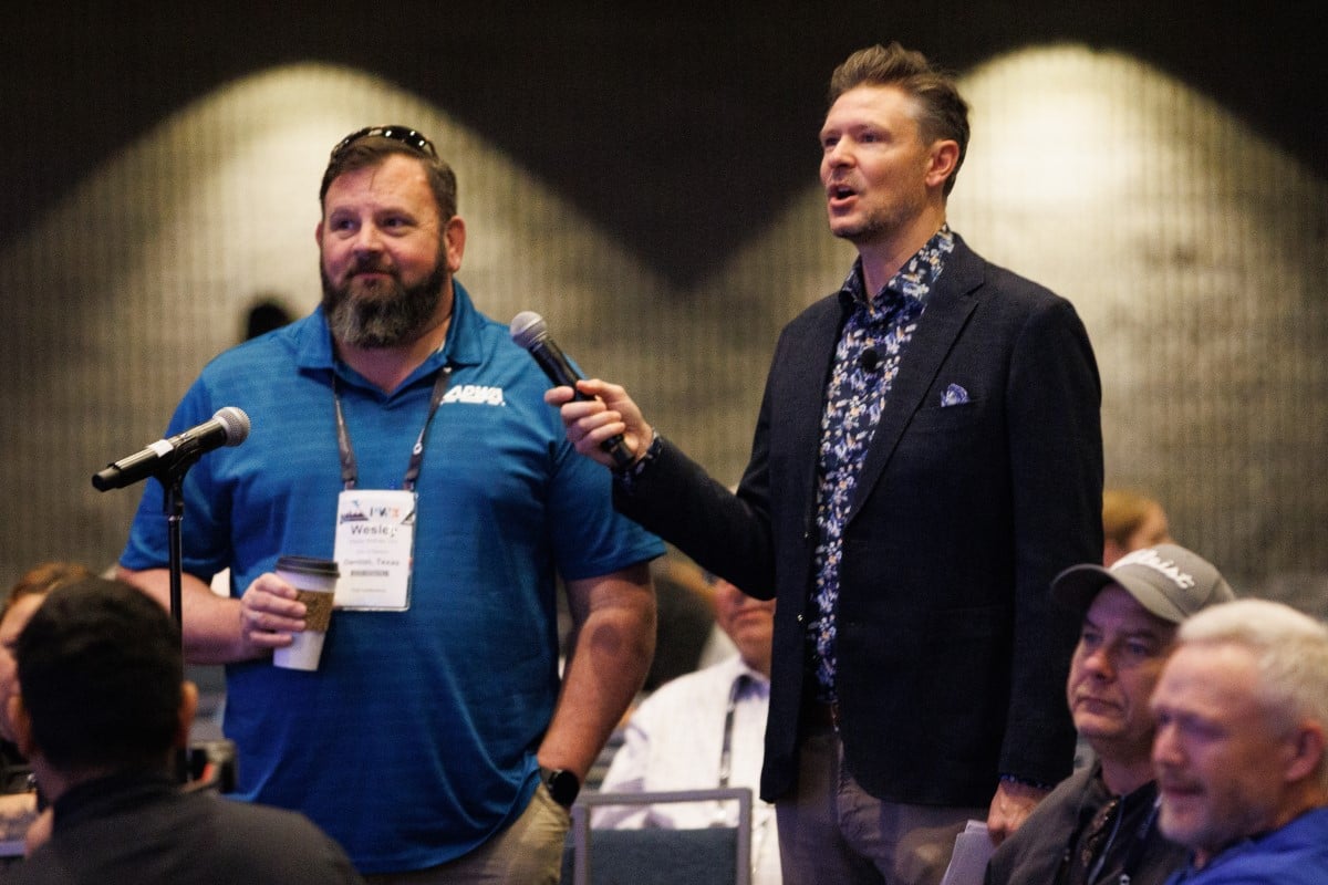 a photo of a conference attendee asking a question of an education session speaker