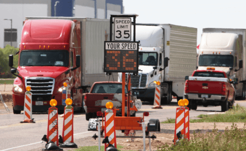 Picture of a truck and speed limit tracker before it alongside a speed 