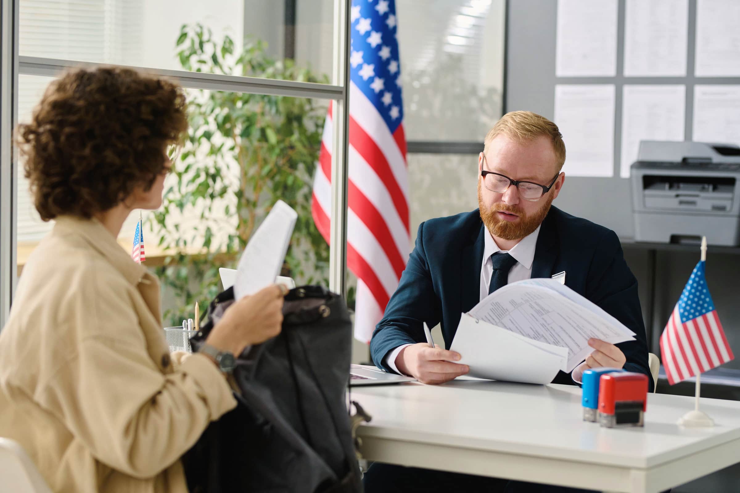 Government affairs Man sitting at desk going over paperwork with woman