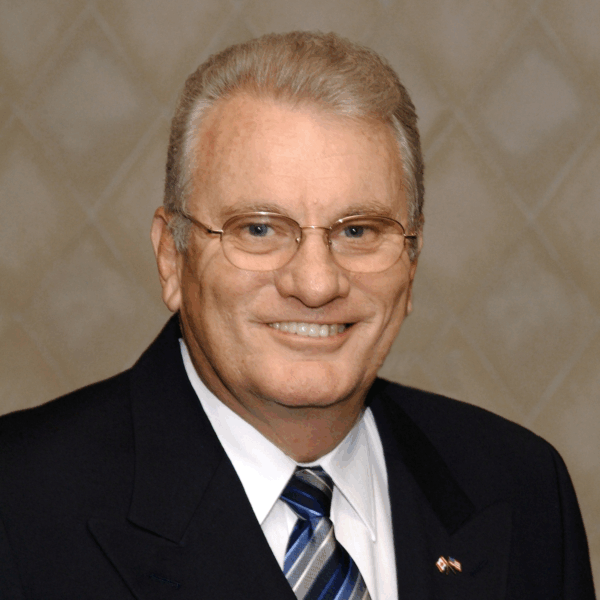 A photograph of Larry Koehle in a suit and tie.