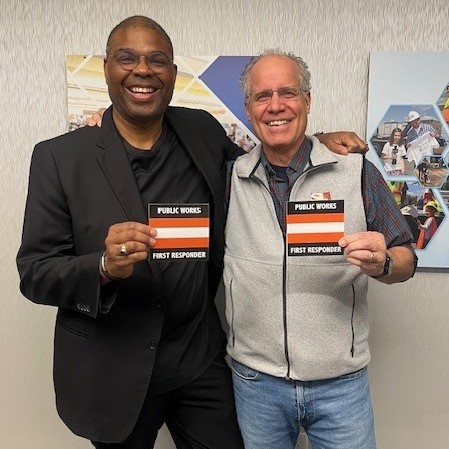 APWA Utah Chapter member and Operations Associate Director for Salt Lake County Public Works Leon Berrett and APWA Government Affairs Manager Marty Williams pose with the Public Works First Responder logo