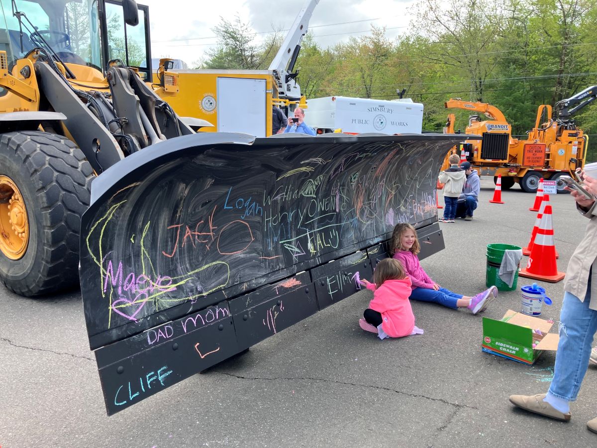 Children enjoy coloring on a loader's blade during National Public Works Week.