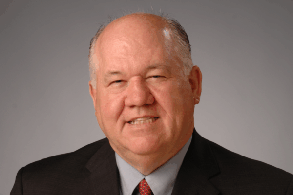 A headshot of APWA Past President Noel Thompson in a suit and tie.