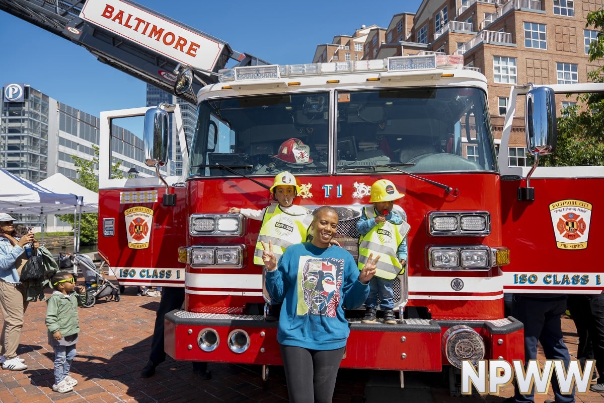 an image of people posing in front of a fire truck during an event celebrating National Public Works Week