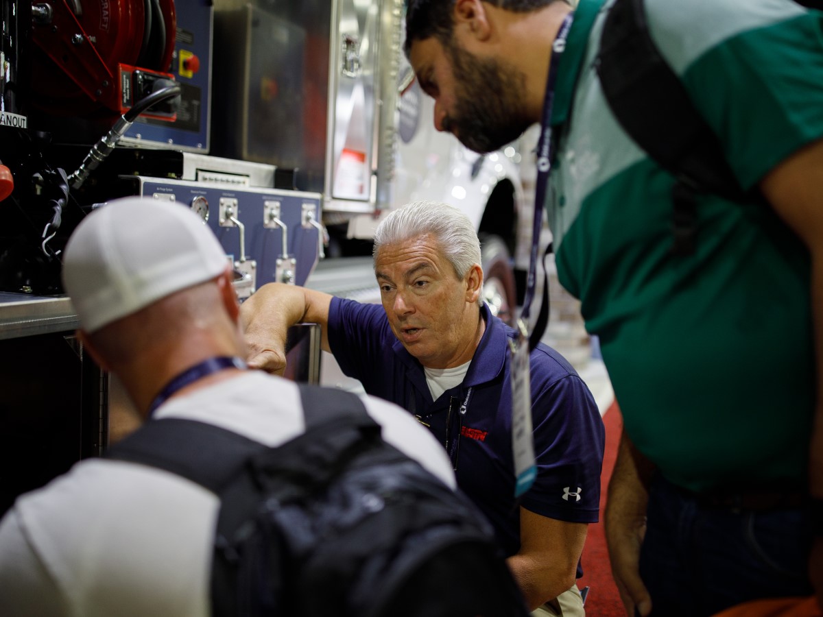 PWX exhibit hall discussion PWX attendees discuss a product with an exhibitor