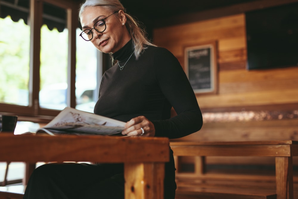 Senior Woman Reading A Magazine At Cafe Mature Female Relaxing