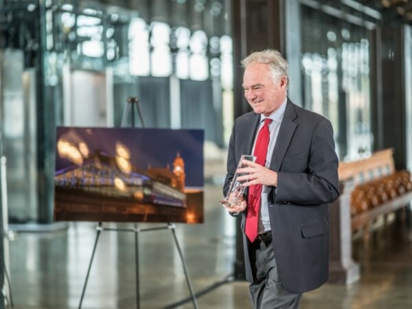 a photo of Senator Tim Kaine holding an award at an Engineering & Public Works Roadshow event