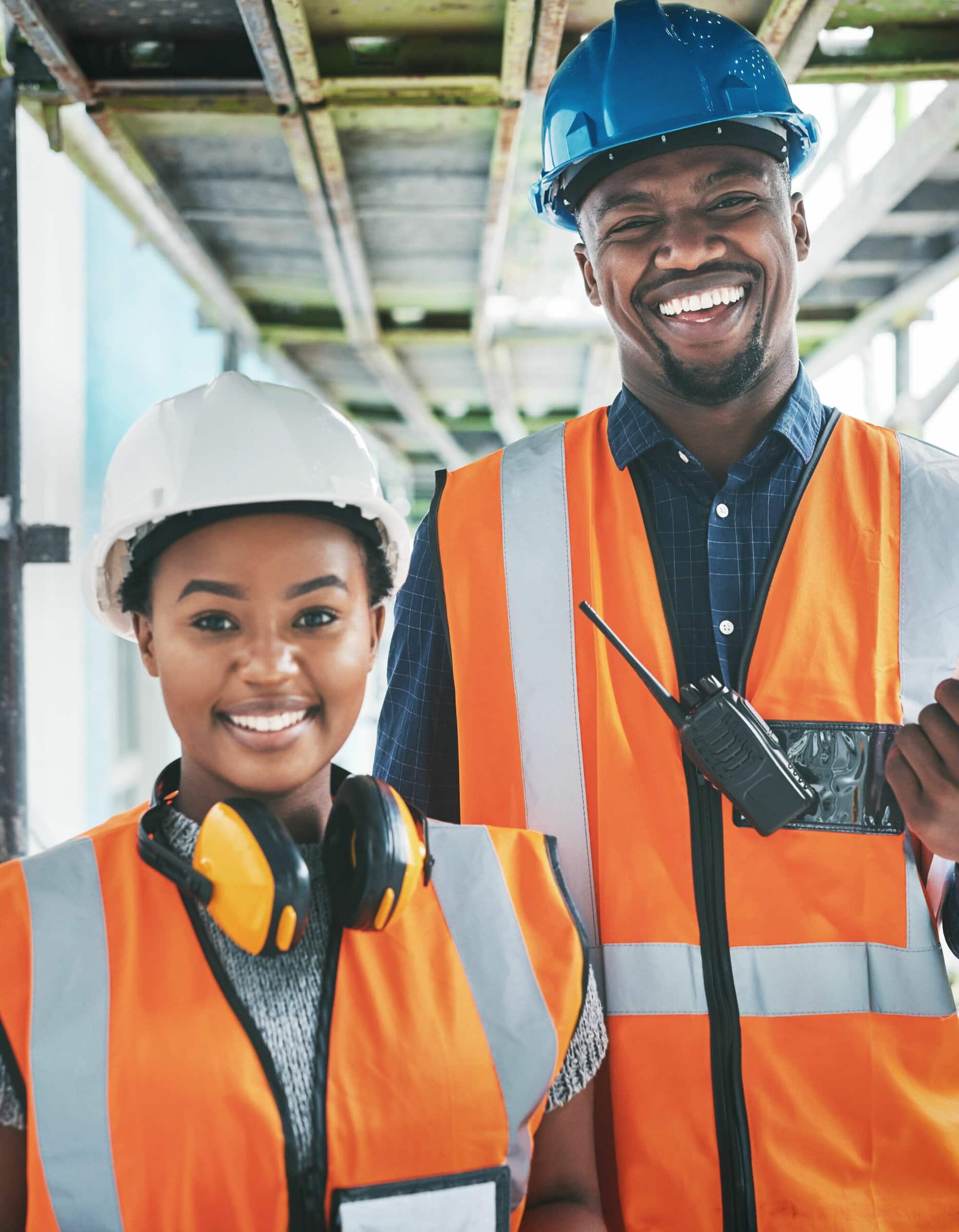 Happy and proud African American engineers at a construction site planning a building together. Portrait of young contractors standing at an apartment to be renovated for a project together