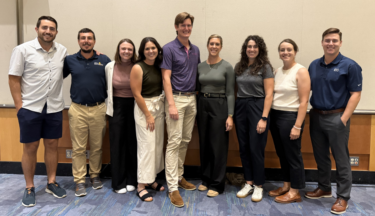 A group of young professionals pose for a group photo.