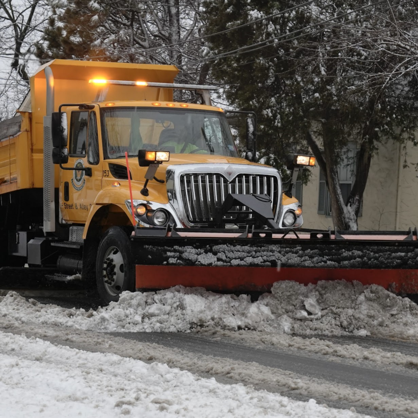 Snow plow removing snow from a street.