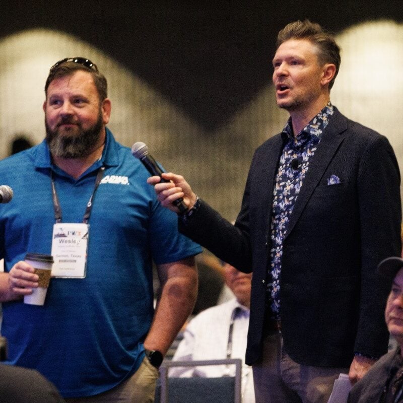 a photo of a conference attendee asking a question of an education session speaker