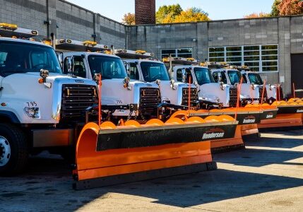 a fleet of trucks with snow plows