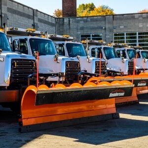 a fleet of trucks with snow plows