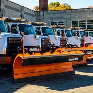 a fleet of trucks with snow plows