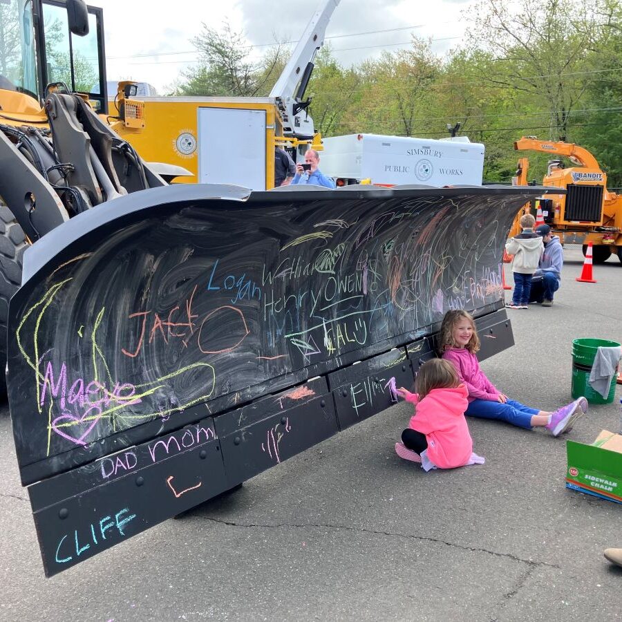 Children enjoy coloring on a loader's blade during National Public Works Week.