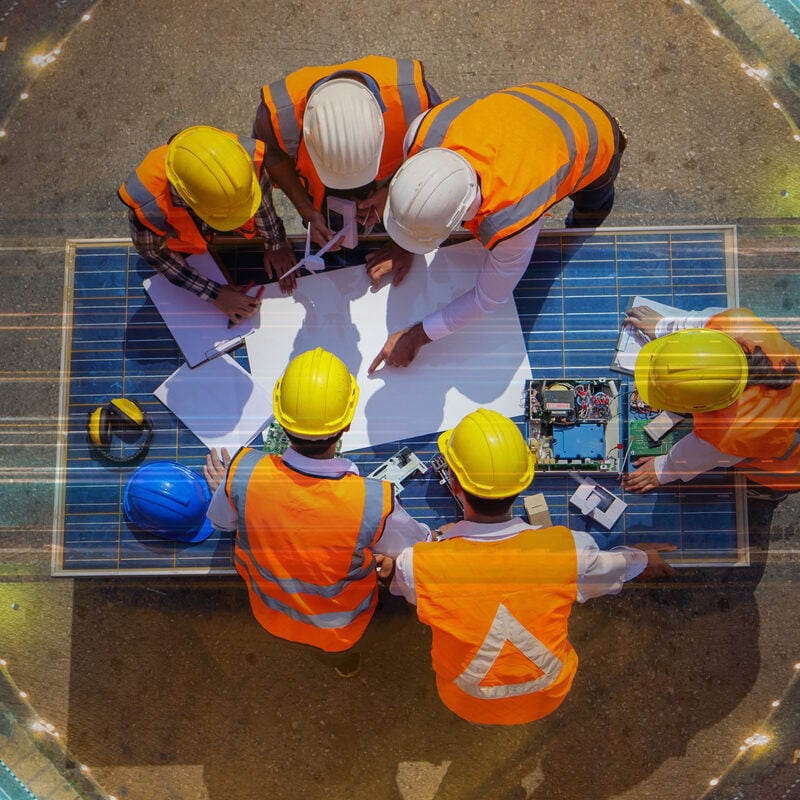 Top view of architectural engineer working on solar panel and his blueprints with Solar photovoltaic equipment on construction site. meeting, Road traffic an important infrastructure
