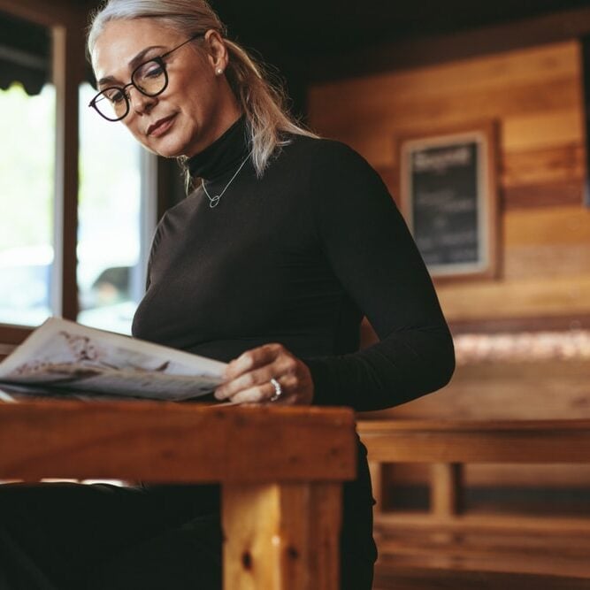 Senior Woman Reading A Magazine At Cafe Mature Female Relaxing