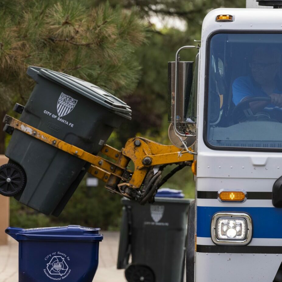 a photo of an automated side loader picking up a cart