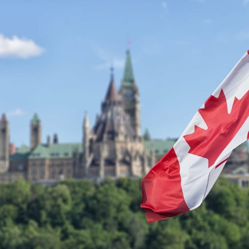 Canada flag with Canadian Parliament in the background