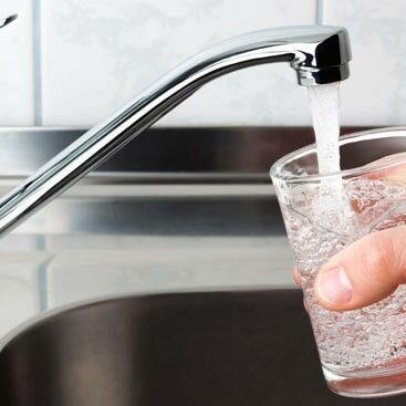 tap water from a faucet flows into a glass