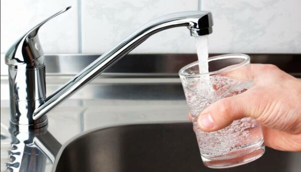 tap water from a faucet flows into a glass